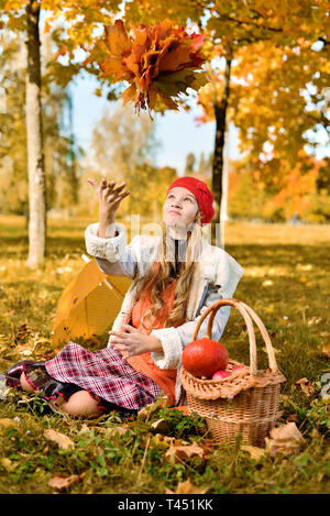 young girl throws bouquet of autumn leaves. happy teenager rejoices Stock Photo