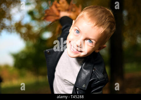 Funny portrait of little sly boy in black leather jacket. autumn season Stock Photo