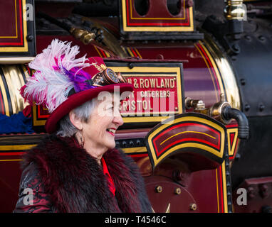 Beamish, Durham County, England, United Kingdom, 13 April 2019. Beamish Steam Day: A female Steampunk enthusiast wearing vintage style clothes and a steampunk hat poses in front of an Anderton & Rowland steam traction engine at Beamish Living Museum Stock Photo