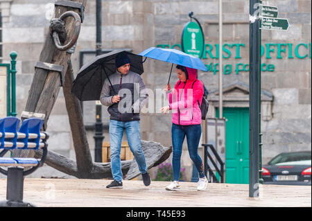 Bantry, West Cork, Ireland. 14th Apr, 2019. Two people walk in the rain in Bantry this afternoon.  County Cork is currently in the midst of a Status Yellow Rainfall and Wind Warning which lasts until 6pm Monday. Credit: Andy Gibson/Alamy Live News. Stock Photo