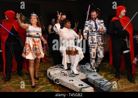 Members of the 81st Surgical Operations Squadron portray the Star Wars cast as they make their way down the aisle during the 31st Annual Krewe of Medics Mardi Gras Ball at the Bay Breeze Event Center on Keesler Air Force Base, Mississippi, Feb. 23, 2019. The Krewe of Medics hosts a yearly ball to give Keesler Medical Center personnel a taste of the Gulf Coast and an opportunity to experience a traditional Mardi Gras, which is celebrated by the local communities. The theme for this year's ball was Hollywood vs. Broadway. Stock Photo