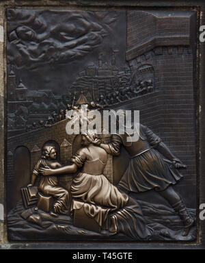 Martyrdom of Saint John of Nepomuk depicted in the bronze relief on the pedestal of the statue of Saint John of Nepomuk on the Charles Bridge in Prague, Czech Republic. Touching the figure of the falling saint is supposed to bring good luck or make a wish. Stock Photo