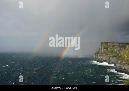A double rainbow over the Cliffs of Moher on the west coast of Ireland in County Clare. Stock Photo