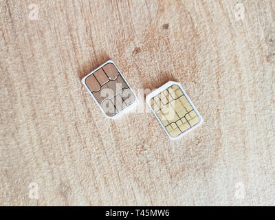 two micro sim cards on a wooden surface background Stock Photo