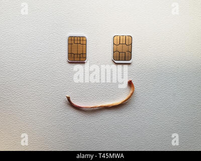 two micro sim cards lying in the shape of a smiling face Stock Photo