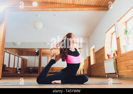 Portrait of sporty beautiful blond woman in sportswear working out indoors, doing variation of Upward Plank Posture, Eka Pada Ardha Purvottanasana on Stock Photo