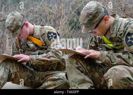 Pvt. Joseph Philbrick, left, multiple launch rocket system (MLRS/HIMARS) crewmember assigned to Battery B., 6th Battalion, 37th Field Artillery Regiment (FAR), 210th Field Artillery Brigade (FAB) and Pvt. Dael Yun, right, Korean Augmentation to the U.S. Army (KATUSA) human resources specialist, assigned to 580th Forward Support Company, 1-38 FAR, 210th FAB, plot points before day land navigation during the 210th FAB 2019 Best Warrior Competition, Camp Casey, Republic of Korea, March 12, 2019. The competition served as a valuable training experience, and the winners will advance to the 2nd Infa Stock Photo