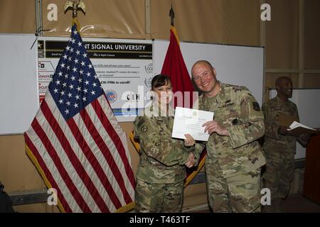 U.S. Army Brig. Gen. Nikki Griffin Olive, commanding general 335th Signal Command (Theater) (Provisional), left, poses with Sgt. 1st Class David Hart after he earned a completion certificate for CompTIA Security+ course at Camp Arifjan, Kuwait, March 1, 2019. The CompTIA Security+ course is designed for system security administrators who will be responsible for conﬁguring and managing a secure networking environment and for implementing security measures and policies. Stock Photo