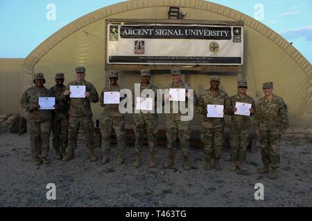 U.S. Army Soldiers assigned to the 335th Signal Command (Theater) (Provisional) and students of the U.S. Army Central Signal University at Camp Arifjan, Kuwait pose for a group photo following graduation, March 1, 2019.  Pictured from left to right: Staff Sgt. Desiree Ruiz, Sgt. 1st Class Carmen Granville, Staff Sgt. James Nowak, Master Sgt. Shakka Bradford, 1st Sgt. Shéshé Lang, Sgt. 1st Class David Hart, 2nd Lt. Brandon Hall, Spc. Jason Loomis, Brig. Gen. Nikki Griffin Olive. Stock Photo