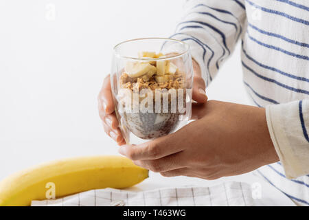 Healthy breakfast with yogurt, nut, banana and chia seeds. Bowl of fresh fruit. Stock Photo
