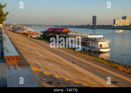 Phnom Penh, Cambodia - March 5, 2019 :  Runner jogging past boats along Mekong River waterfront in Phnom Penh, Cambodia at daybreak. Stock Photo