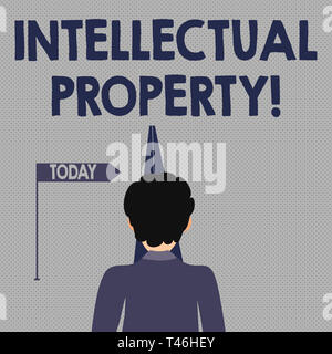 Writing note showing Intellectual Property. Business concept for Ownership of an idea or design by the demonstrating Man Facing Distance and Blocking  Stock Photo