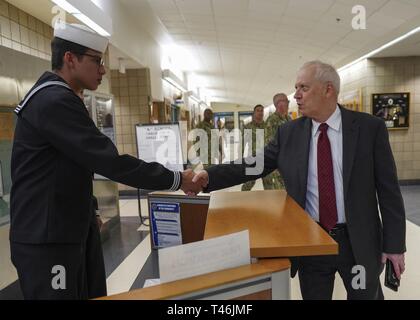 PENSACOLA, Fla. (March 13, 2019) Airman Recruit Sebastian Pineda, left, a student standing quarterdeck watch at Naval Air Technical Training Center (NATTC), shakes hands with Charles Drummond, deputy assistant secretary of defense for education and training in the Office of the Assistant Secretary of Defense for Readiness.  Drummond toured NATTC during a visit to Pensacola that also included Naval Education and Training Command, where he discussed topics such as credentialing; Ready, Relevant Learning; and information technology transformation initiatives. Stock Photo