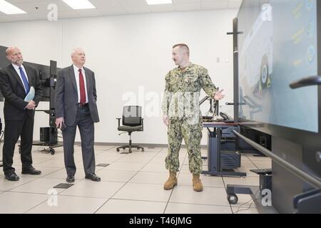 PENSACOLA, Fla. (March 13, 2019) Aviation Support Equipment Technician 1st Class Randy Miracle, right, demonstrates the Multipurpose Reconfigurable Training System (MRTS) 3D Mobile Electric Power Plant (MEPP) simulator at Naval Air Technical Training Center to Charles Drummond, deputy assistant secretary of defense for education and training in the Office of the Assistant Secretary of Defense for Readiness.  MRTS 3D allows Sailors to use touch screens to see and access parts of tactical equipment in a video game simulation environment. MRTS 3D is an example of the kind of technology Naval Air  Stock Photo