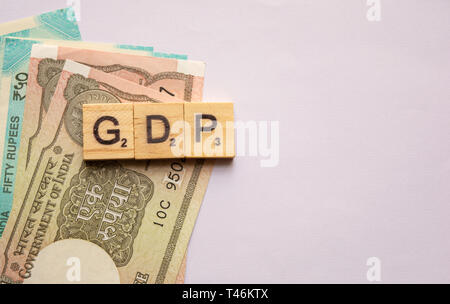 Maski,India 13,April 2019 : GDP or gross domestic product in wooden block letters with Indian currency on isolated background. Stock Photo