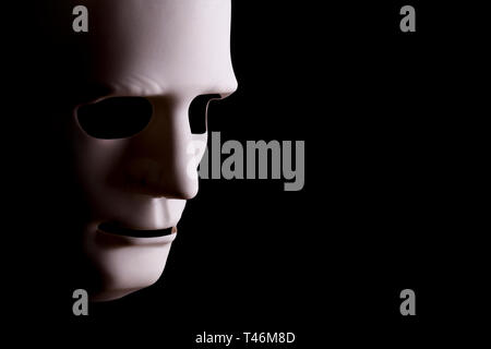Blank robotic face mask looking sideways with a black background and copy space. Stock Photo