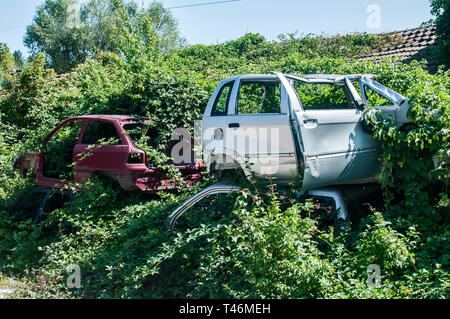 Old crushed cars bodies stored in auto wrecking junk yard for scrap and spare parts Stock Photo