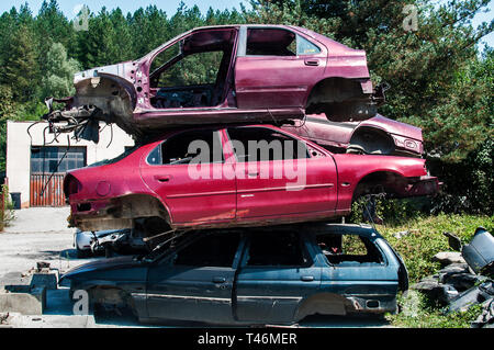 Old crushed cars bodies stored in auto wrecking junk yard for scrap and spare parts Stock Photo