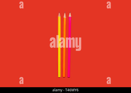 colored pencils lying on a red background Stock Photo