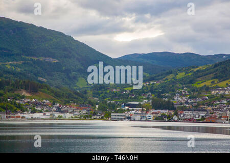 Small Norwegian town on the shore of a fjord in Norway. Private houses on the slopes of the highlands of Norway. Stock Photo