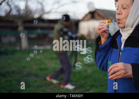 Woman blowing soap bubbles, memories of childhood Stock Photo