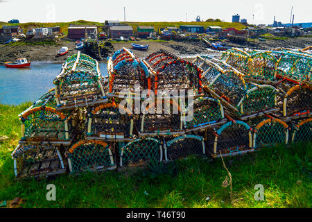 Fishing boats aground at low tide in Paddys Hole Harbour, on a spring day with traditional lobster or crab pots in the foreground at Teesmouth Redcar Stock Photo