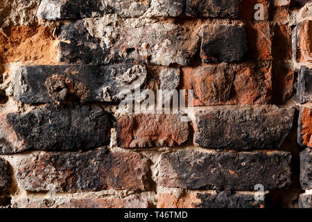 Rough brick wall of dirty brown color close up. Wall with old crumbling brickwork. Background. Stock Photo