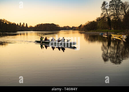 Mixed ages (including older people), paddling a V6 hawaiian outrigger (Va'a) on Trentham lake, Stoke-on-Trent, UK. Members of Trentham canoe club Stock Photo