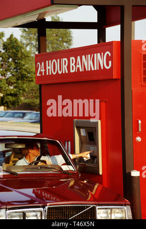 1995, Man conducting Transaction at a drive thru 24 hour ATM, USA Stock Photo