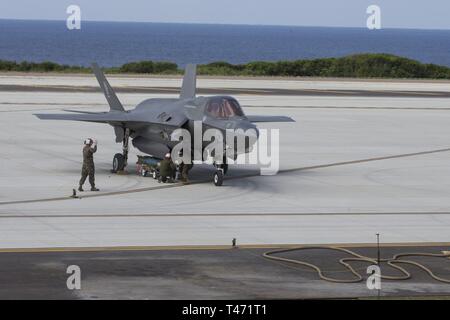 An F-35B Lightning II fighter aircraft with Marine Fighter Attack Squadron 121 is loaded with a Guided Bomb Unit at an established Forward Arming and Refueling Point during simulated Expeditionary Advanced Base Operations at Ie Shima Training Facility, March 14, 2019. Marines with the 31st Marine Expeditionary Unit are conducting simulated EABO in a series of dynamic training events to refine their ability to plan, rehearse and complete a variety of missions. During EABO, the 31st MEU partnered with the 3rd Marine Division, 3rd Marine Logistics Group and 1st Marine Aircraft Wing, and airmen wi Stock Photo