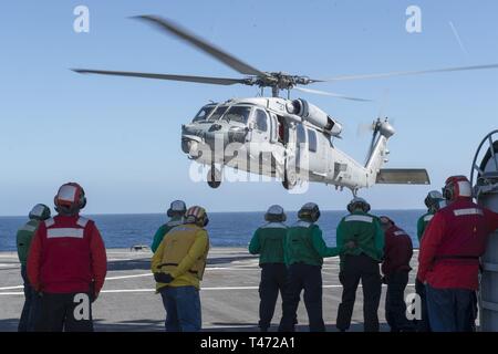 SEA (March 15, 2019) – Admiral James G. Foggo III departs the Blue Ridge-class command and control ship USS Mount Whitney aboard a MH-60S Seahawk helicopter. Mount Whitney, forward- deployed to Gaeta, Italy, operates with a combined crew of U.S. Navy Sailors and Military Sealift Command civil service mariners. Stock Photo