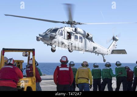 SEA (March 15, 2019) – Admiral James G. Foggo III departs the Blue Ridge-class command and control ship USS Mount Whitney aboard a MH60S Seahawk helicopter. Mount Whitney, forward- deployed to Gaeta, Italy, operates with a combined crew of U.S. Navy Sailors and Military Sealift Command civil service mariners. . Stock Photo