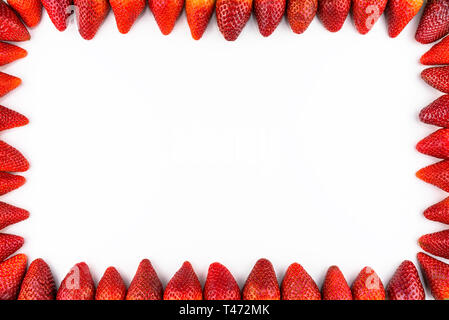 Frame made from fresh strawberries, top view, flat lay, isolated on a white background with copy space in the middle. Stock Photo