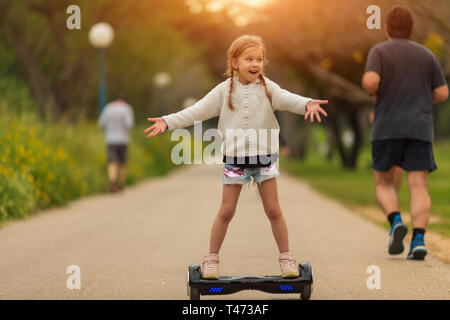 Girl learning to ride hoverboard. Modern gadgets for school kid Stock Photo