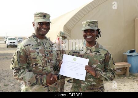 U.S. Army Lt. Col. Joseph Gardner, commander 54th Signal Battalion, left, poses with Sgt. 1st Class Carmen Granville after she earned a completion certificate for the CompTIA A+ 901 course at Camp Arifjan, Kuwait, March 15, 2019.  The A+ 901 course covers the fundamentals of computer technology, installation and configuration of PCs, laptops and related hardware as well as some basic networking concepts. Stock Photo