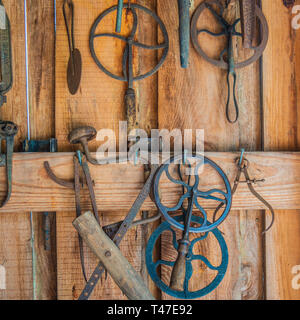Antique Tools Hanging on Rustic Wooden Wall Stock Photo