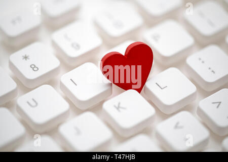 Small red heart on computer keyboard. Internet dating concept. Stock Photo