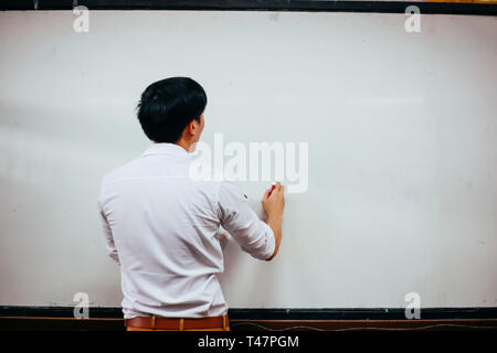 Businessman drawing and writing something on white board - with copy space Stock Photo