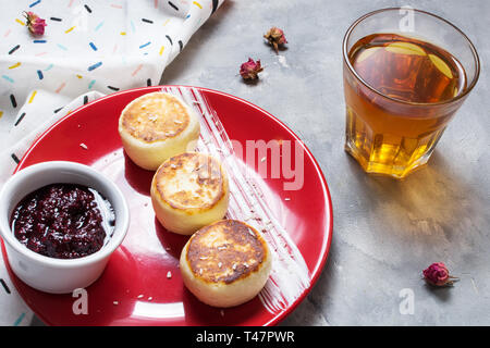 Cottage cheese pancakes on concrete background. Syrniki with jam. Homemade food Stock Photo