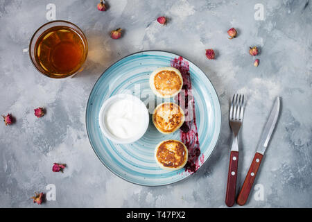 Cottage cheese pancakes on concrete background. Syrniki with jam. Homemade food. Top view Stock Photo