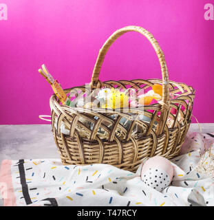Basket with easter cakes and painted eggs on concrete background. Easter concept Stock Photo