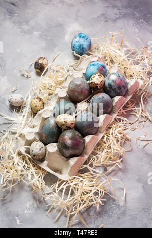 Quail and chicken painted eggs on concrete background. Easter decorations. Stock Photo