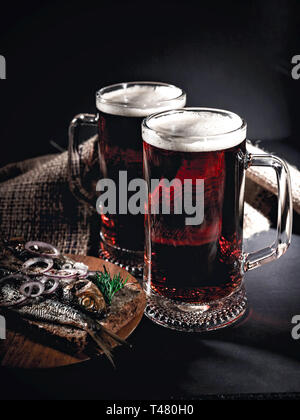 Red craft beer, hot smoked fish sandwich on a dark background. Low key lighting. Vertical shot Stock Photo