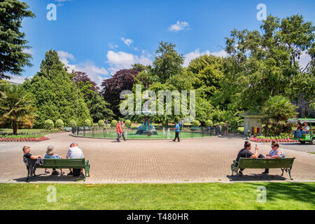 8 January 2019: Christchurch, New Zealand - People sitting and walking near the Peacock Fountain in Christchurch Botanic Gardens. Stock Photo