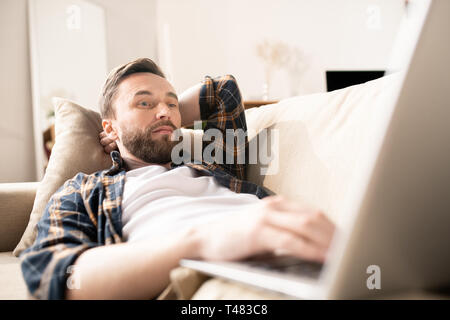 Watching video on couch Stock Photo