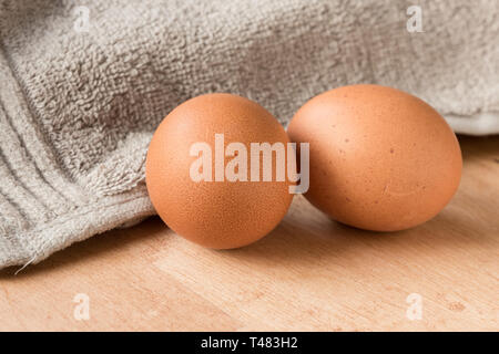 Two brown eggs on a wooden kitchen table. Stock Photo