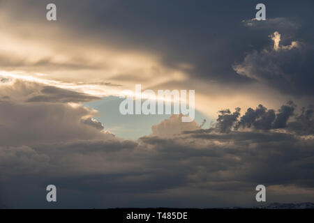 Blue Sky hole in dark clouds Stock Photo