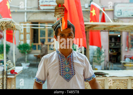 KASHGAR, XINJIANG / CHINA - : Portrait of a young Uyghur man at a bazaar in Kashgar. Stock Photo
