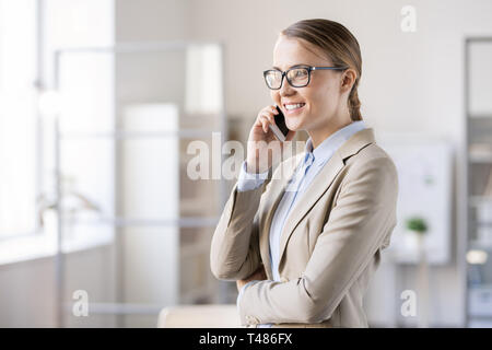 Happy young female manager talking to customer on phone Stock Photo