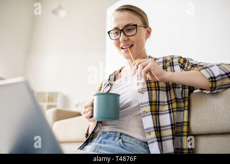 Thoughtful woman studying information online  Stock Photo